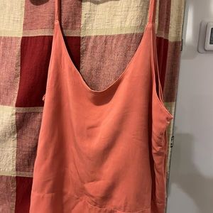 Silk cotton material tank top with straps. Color is a coral/clay color.